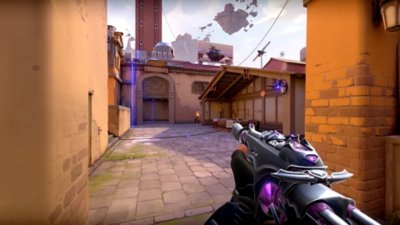 Valorant screenshot with a player holding their gun forward, featuring glowing purple patches on the weapon